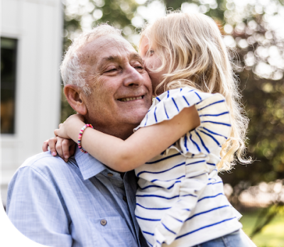 Smiling grandpa playing with his granddaughter